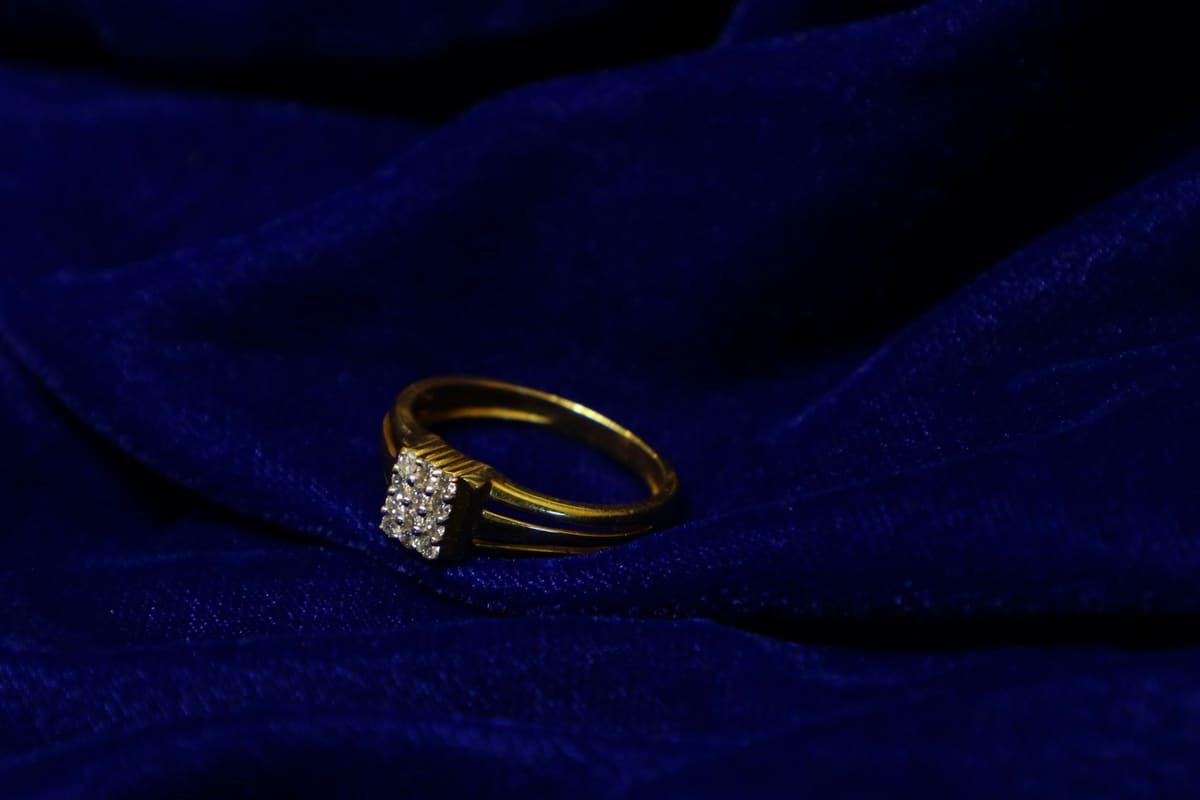 Collar y anillos de oro sobre un fondo oscuro