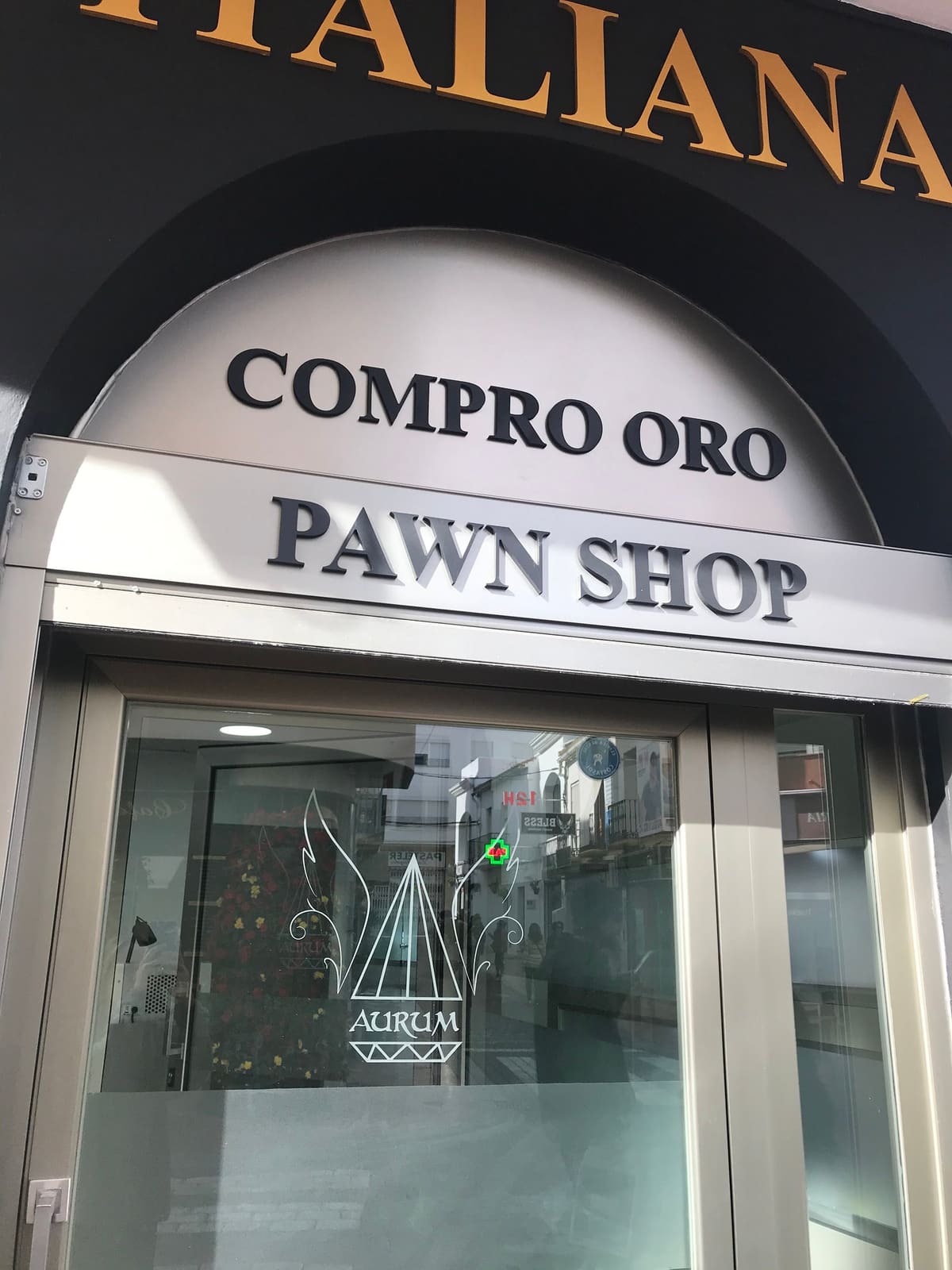 The Aurum entrance in Estepona with Compro oro and Pawn shop signs